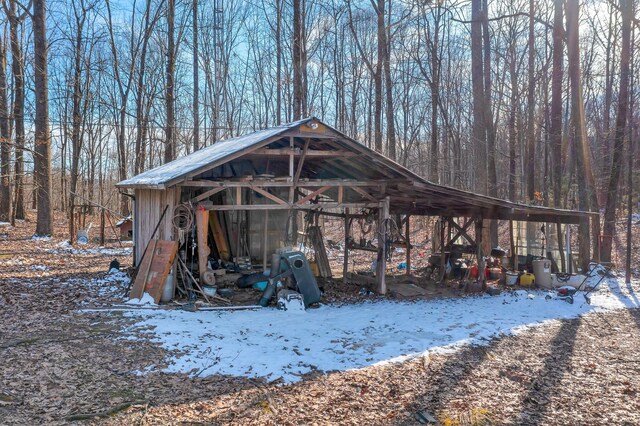 snow covered structure featuring an outbuilding
