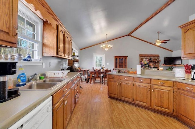 kitchen featuring white dishwasher, light wood-style floors, vaulted ceiling, light countertops, and hanging light fixtures