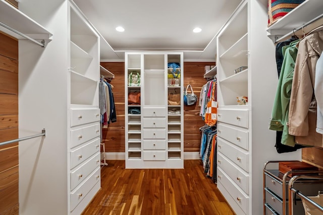 walk in closet with dark wood-style floors