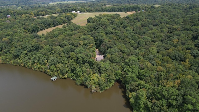 birds eye view of property featuring a water view and a wooded view