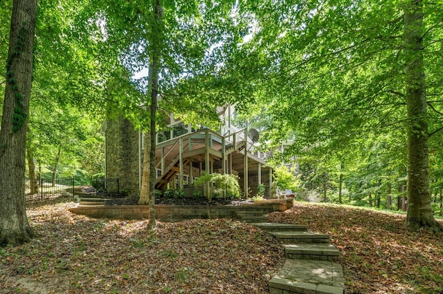 back of property with stairs, fence, and a wooden deck