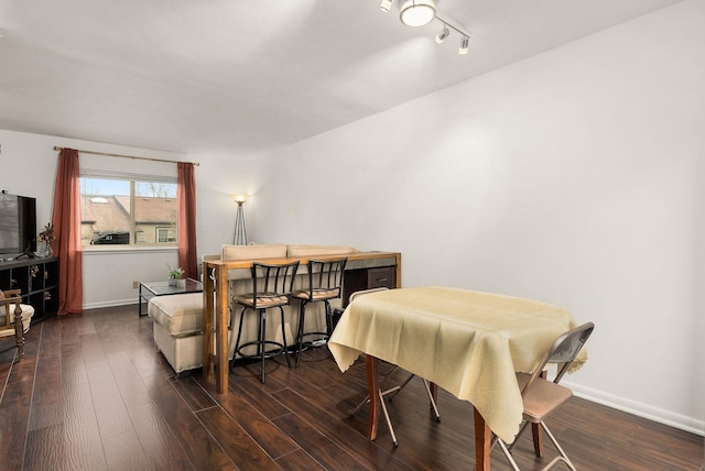 dining area featuring dark wood-style floors and baseboards