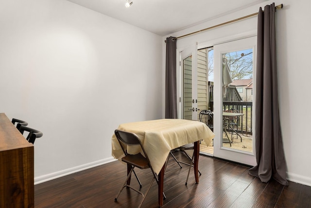 dining space featuring dark wood-style floors and baseboards