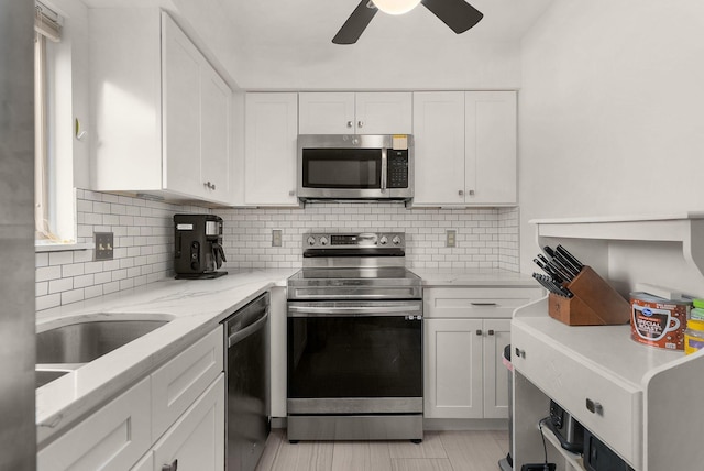 kitchen featuring white cabinetry, stainless steel appliances, and backsplash