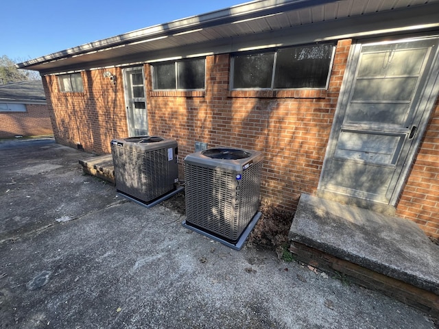 details featuring central air condition unit and brick siding