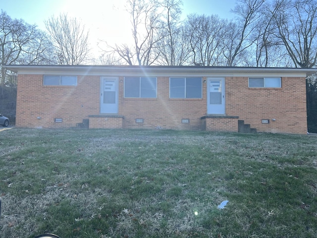 view of front of property featuring crawl space, brick siding, and a front lawn