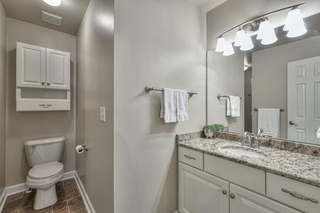 bathroom featuring toilet, baseboards, visible vents, and vanity