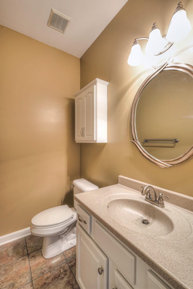 half bathroom featuring toilet, baseboards, visible vents, and vanity