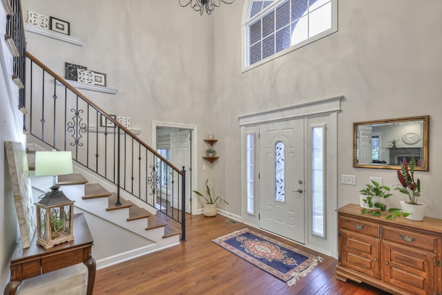 foyer featuring stairway, wood finished floors, a wealth of natural light, and baseboards