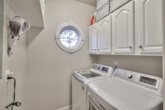 washroom featuring cabinet space and washer and clothes dryer