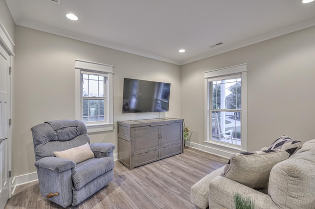 living area with light wood finished floors, plenty of natural light, ornamental molding, and baseboards