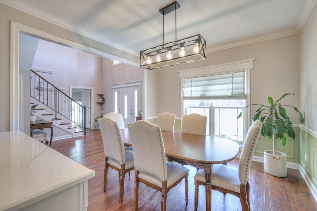 dining area featuring ornamental molding, stairway, and wood finished floors