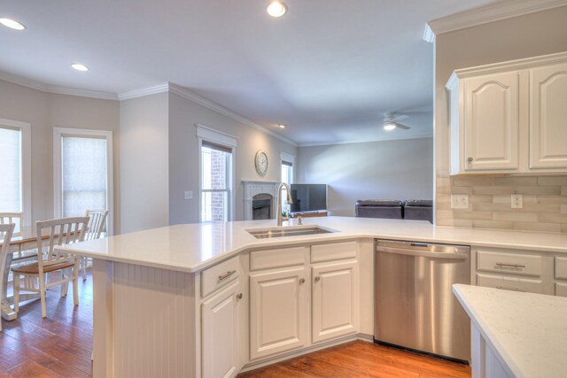 kitchen featuring open floor plan, white cabinetry, a sink, wood finished floors, and dishwasher