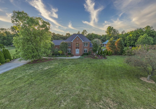 view of front of home featuring a front lawn and brick siding