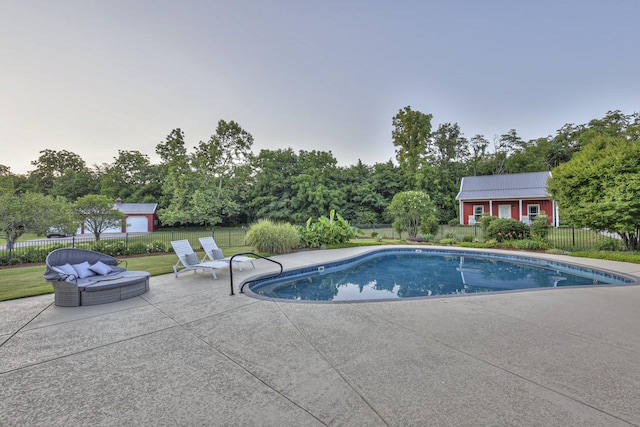 view of swimming pool with an outbuilding, fence, a fenced in pool, a patio area, and an exterior structure