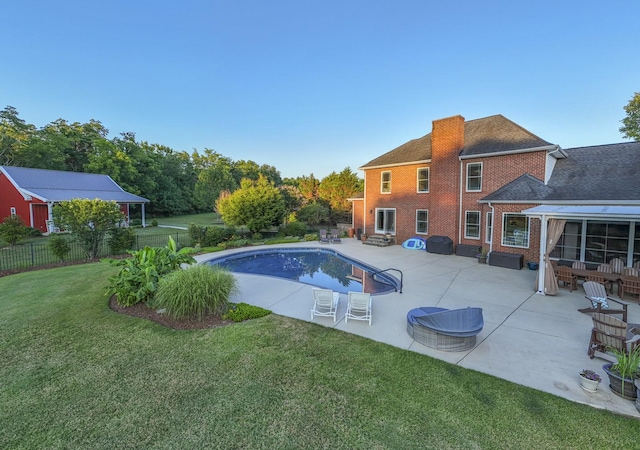 outdoor pool featuring fence, a patio, and a yard