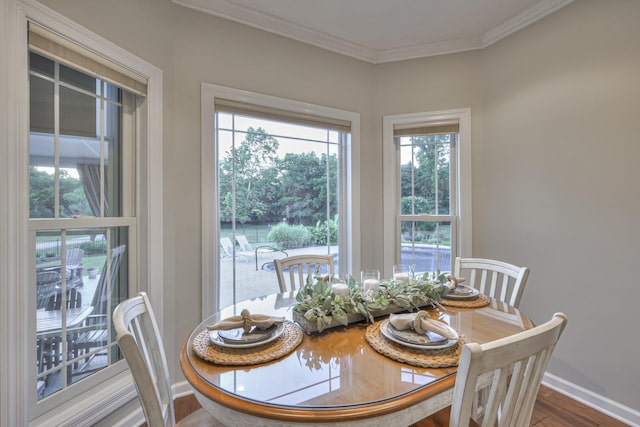 dining space featuring baseboards, wood finished floors, and crown molding