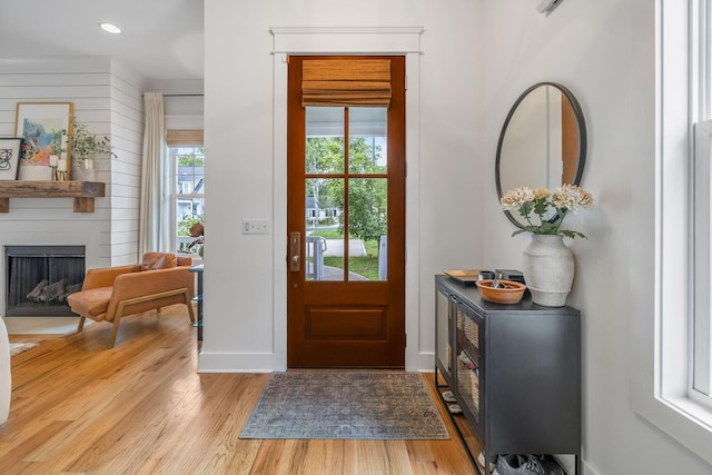 entrance foyer with a large fireplace, light wood-type flooring, and recessed lighting