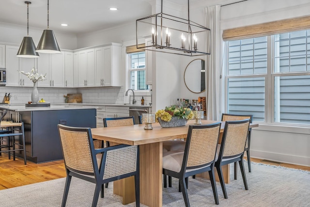 dining room featuring light wood-style floors, baseboards, a chandelier, and recessed lighting