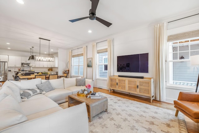 living area featuring light wood-type flooring, ceiling fan, baseboards, and recessed lighting