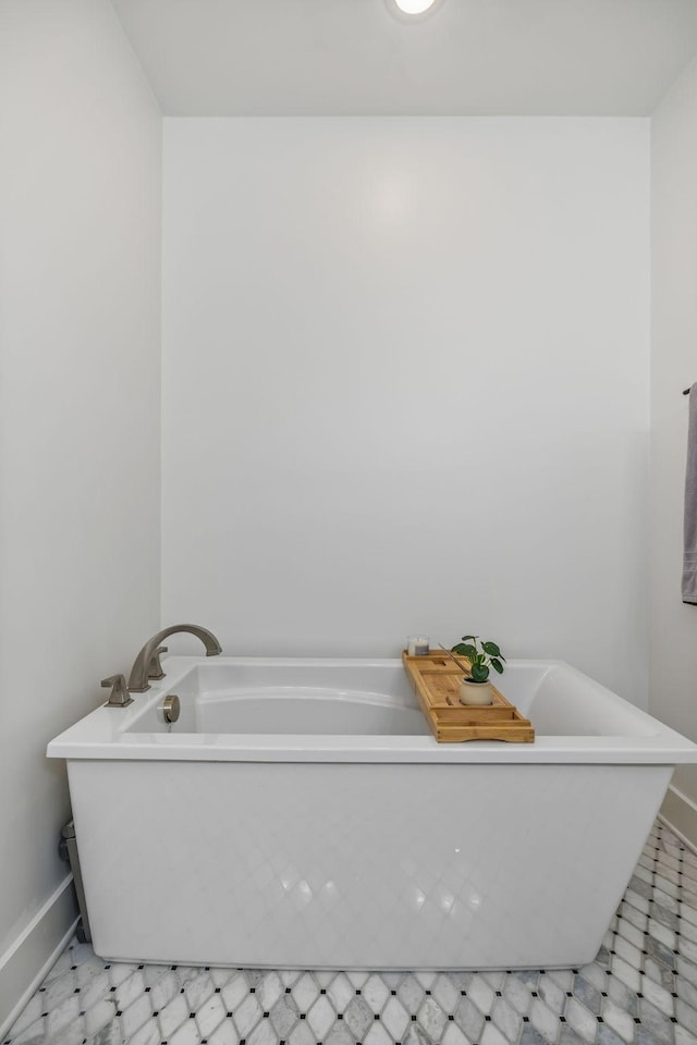 full bath with a freestanding tub and baseboards