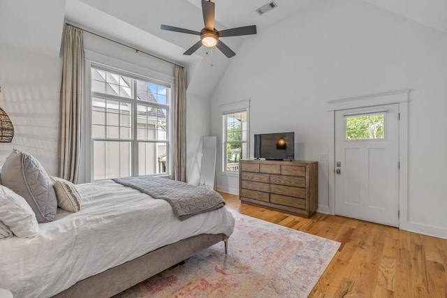 bedroom with high vaulted ceiling, baseboards, visible vents, and light wood finished floors