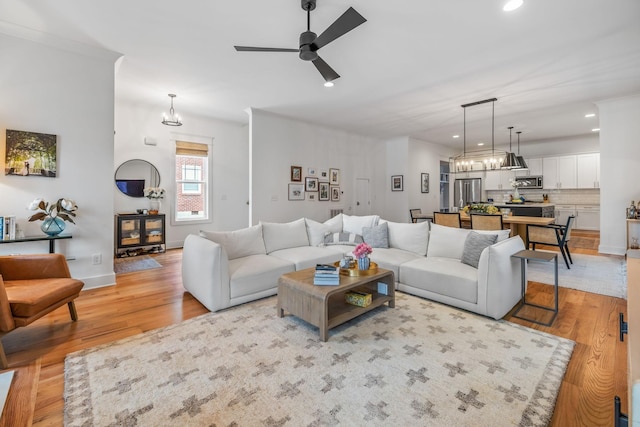 living area with light wood-type flooring, ceiling fan, and recessed lighting