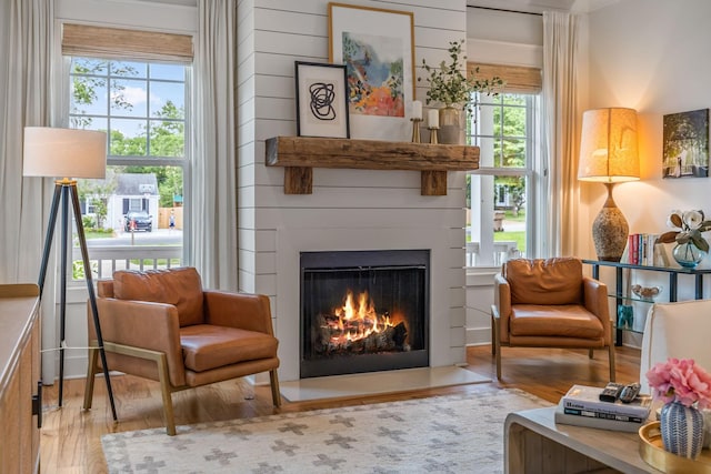 living area featuring a lit fireplace and light wood-type flooring