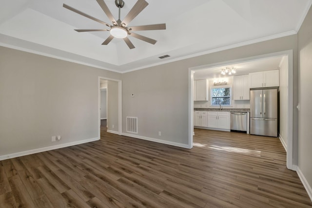 unfurnished living room featuring dark wood-style flooring, visible vents, a sink, and baseboards