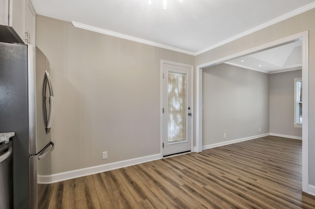 interior space with crown molding, dark wood-type flooring, freestanding refrigerator, white cabinetry, and baseboards