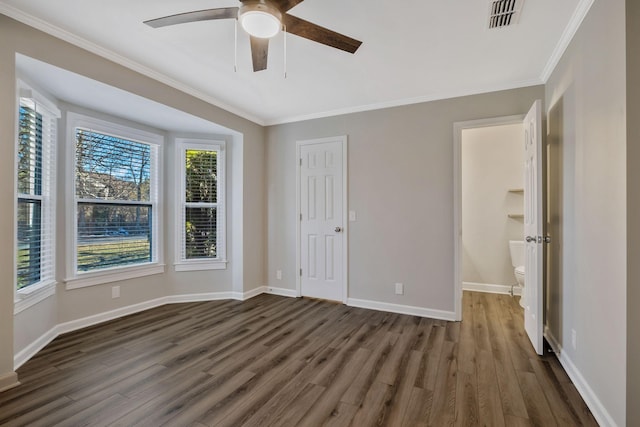 unfurnished room with crown molding, visible vents, dark wood-type flooring, ceiling fan, and baseboards