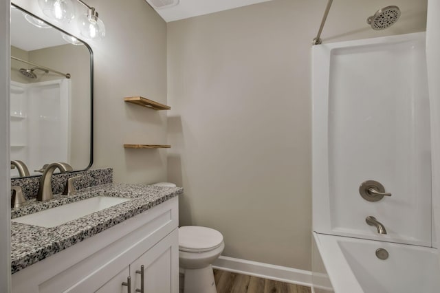 full bath featuring shower / bathing tub combination, toilet, vanity, wood finished floors, and baseboards