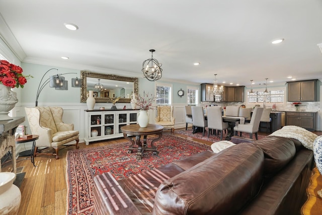 living room featuring recessed lighting, wood finished floors, crown molding, and wainscoting