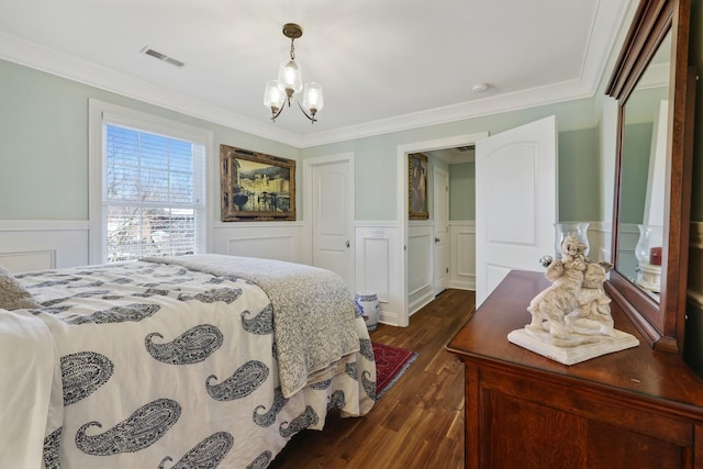 bedroom with a closet, visible vents, dark wood-style floors, crown molding, and a notable chandelier