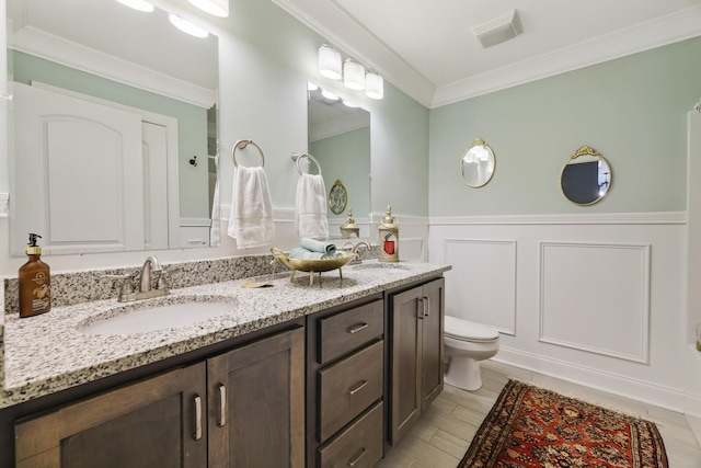 full bathroom featuring ornamental molding, a wainscoted wall, and a sink