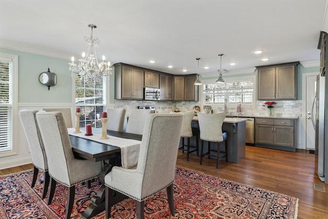 dining area with ornamental molding, dark wood-style flooring, and recessed lighting