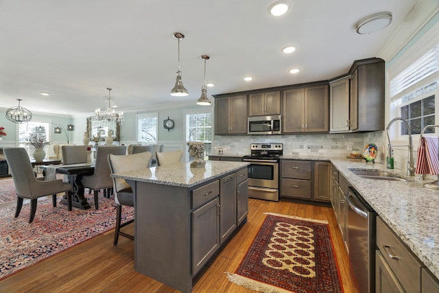 kitchen featuring crown molding, a breakfast bar area, stainless steel appliances, tasteful backsplash, and a sink