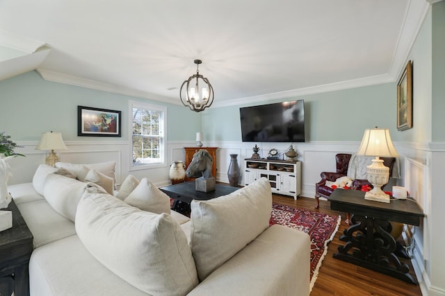 living area featuring a notable chandelier, ornamental molding, wood finished floors, and wainscoting