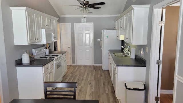 kitchen featuring dark countertops, white appliances, white cabinets, and crown molding