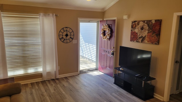 entryway featuring baseboards, crown molding, and wood finished floors