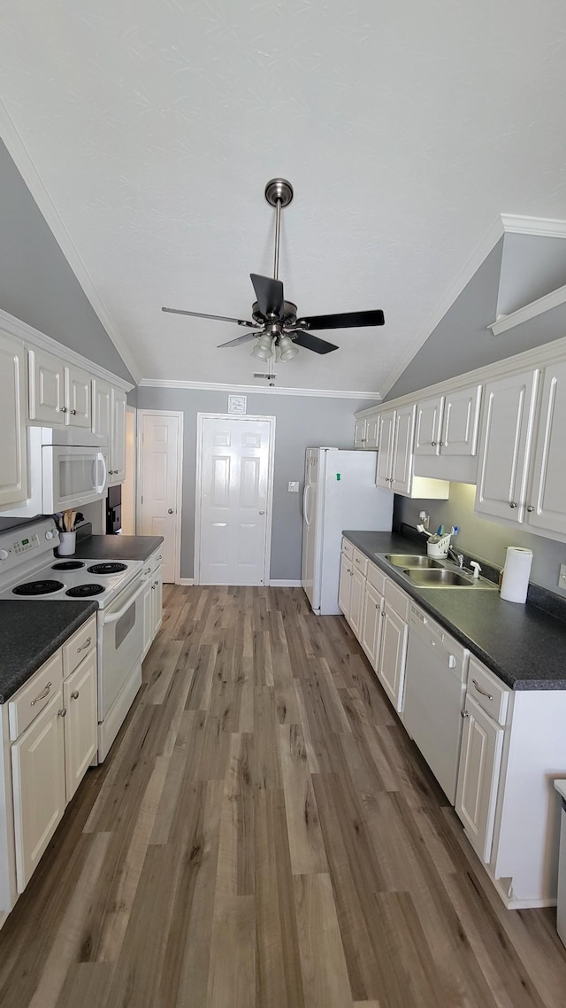 kitchen featuring dark countertops, white appliances, and white cabinets