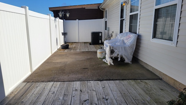 wooden terrace featuring fence, grilling area, and cooling unit