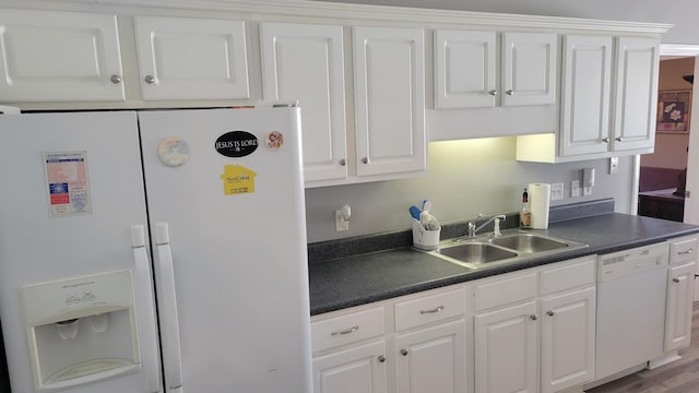 kitchen featuring white appliances, white cabinets, and a sink