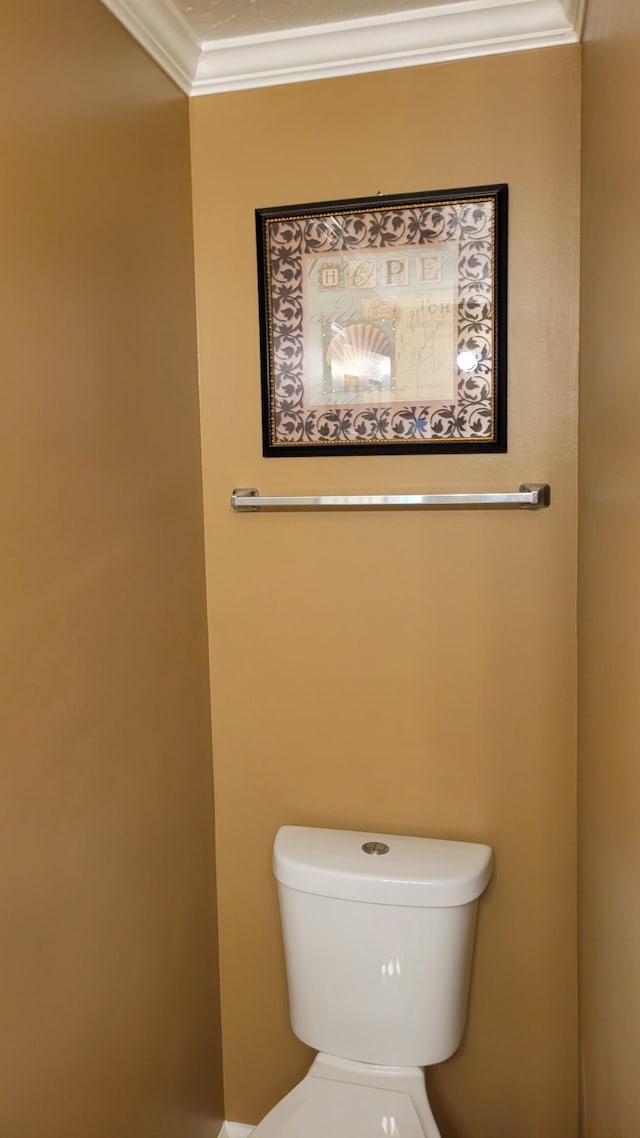 bathroom with ornamental molding and toilet