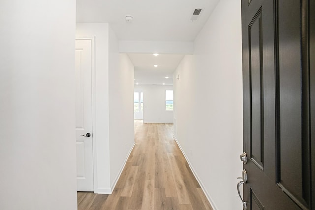 hall featuring light wood-style floors, recessed lighting, visible vents, and baseboards