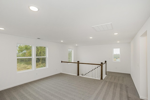 carpeted empty room featuring baseboards, visible vents, and recessed lighting