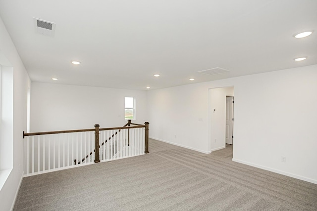 empty room with recessed lighting, visible vents, and baseboards