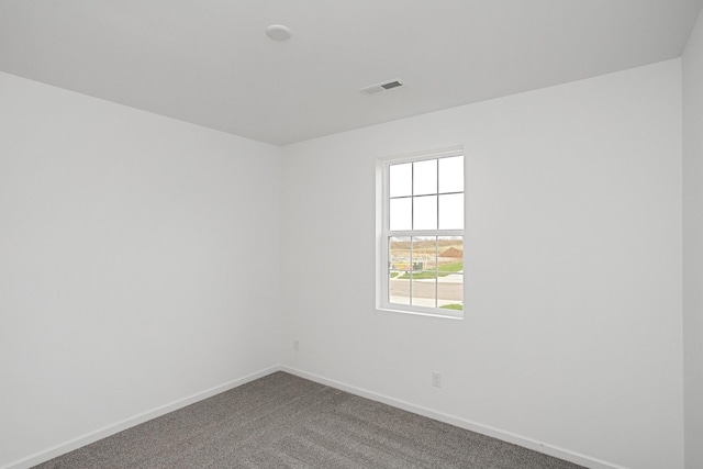 carpeted spare room featuring visible vents and baseboards