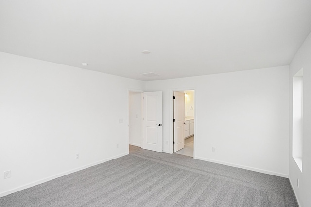 empty room with light colored carpet and baseboards