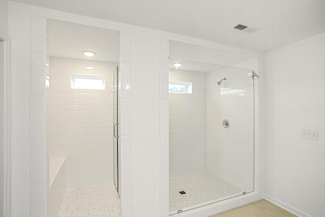 bathroom with a stall shower, visible vents, and tile patterned floors